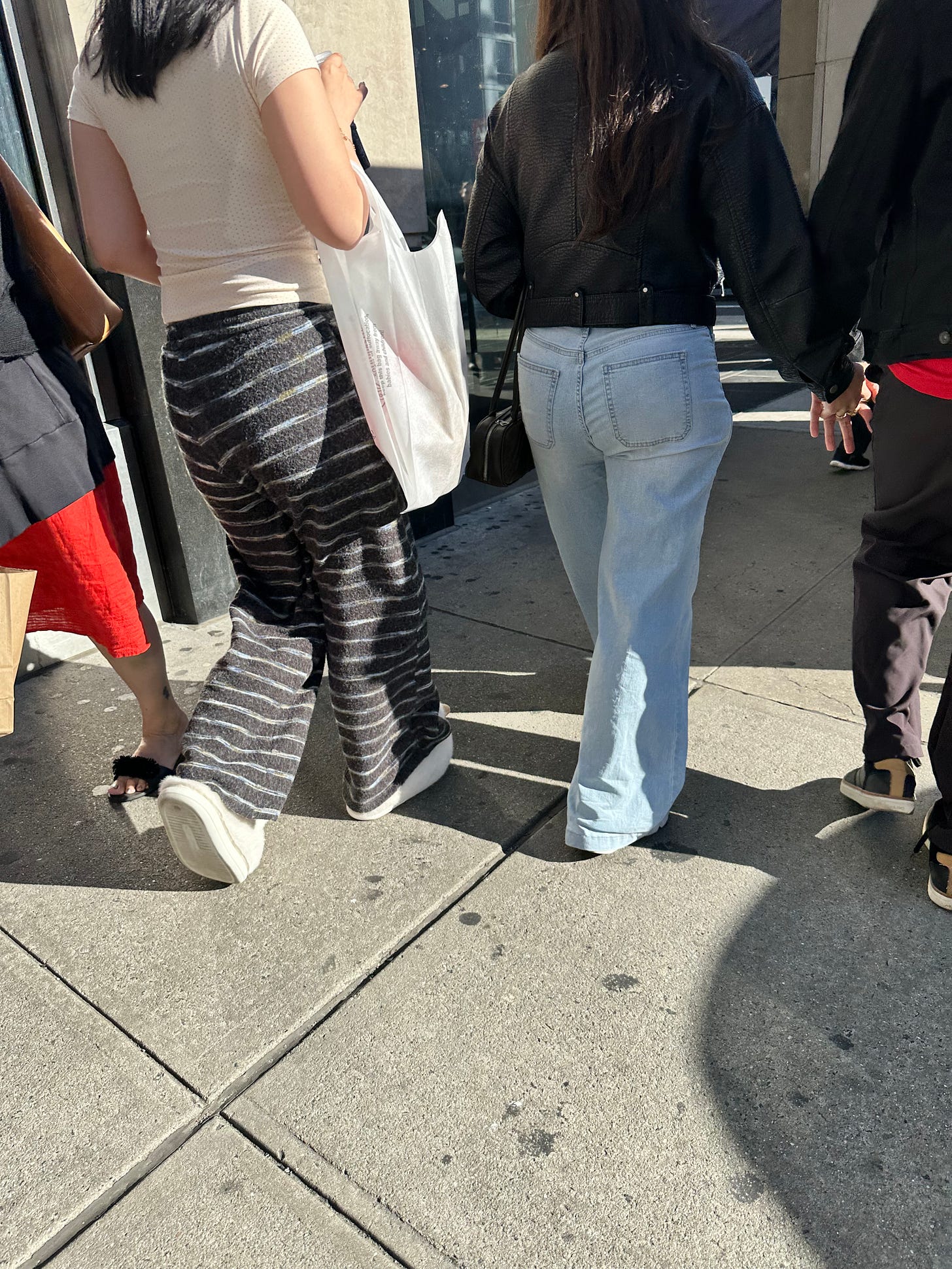 a woman in pajamas and soft ducky slippers walks on a city street a woman in pajamas and soft ducky slippers walks on a city street
