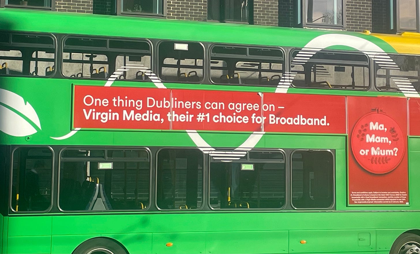 On the side of a green bus: ""Ma, Mam, or Mum? One thing Dubliners can agree on— [company name], their #1 choice for broadband"