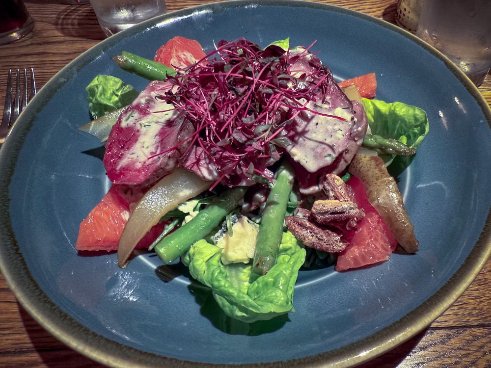 An elaborate dish of pigeon salad sits on a plate
