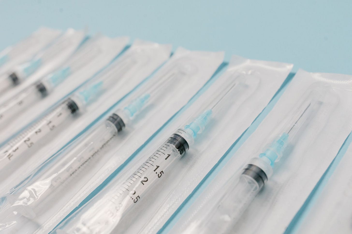Photo by Tara Winstead on Pexels Close-up of sterile syringes aligned on a light blue surface, highlighting medical equipment. (stock photo)