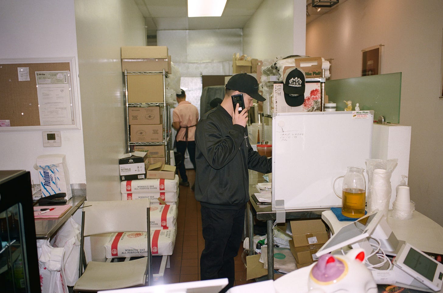 Ken Hy answers the phone at Banh Mi Hoa Phat