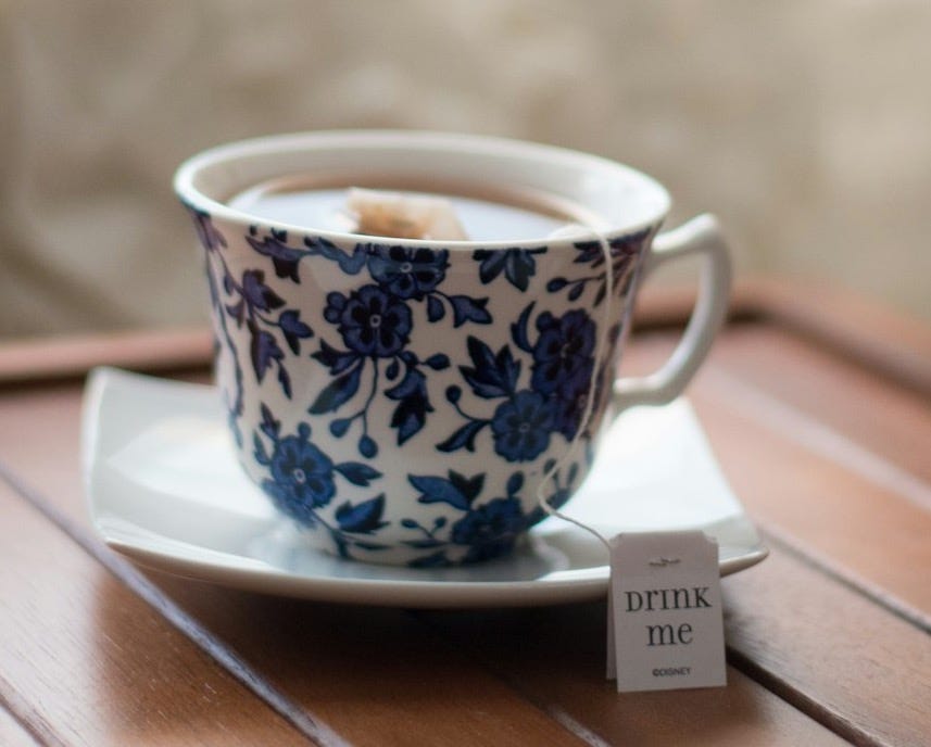 white and blue floral teacup with tea bag in saucer in tilt shift photography