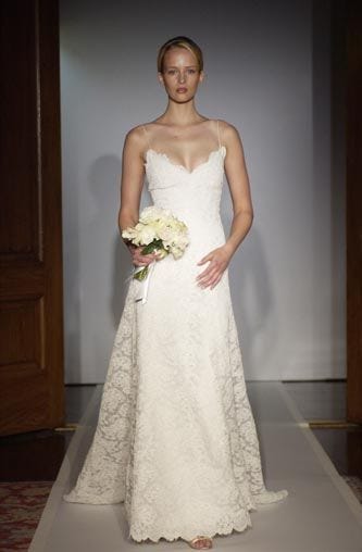 This may contain: a woman in a wedding dress standing on a runway