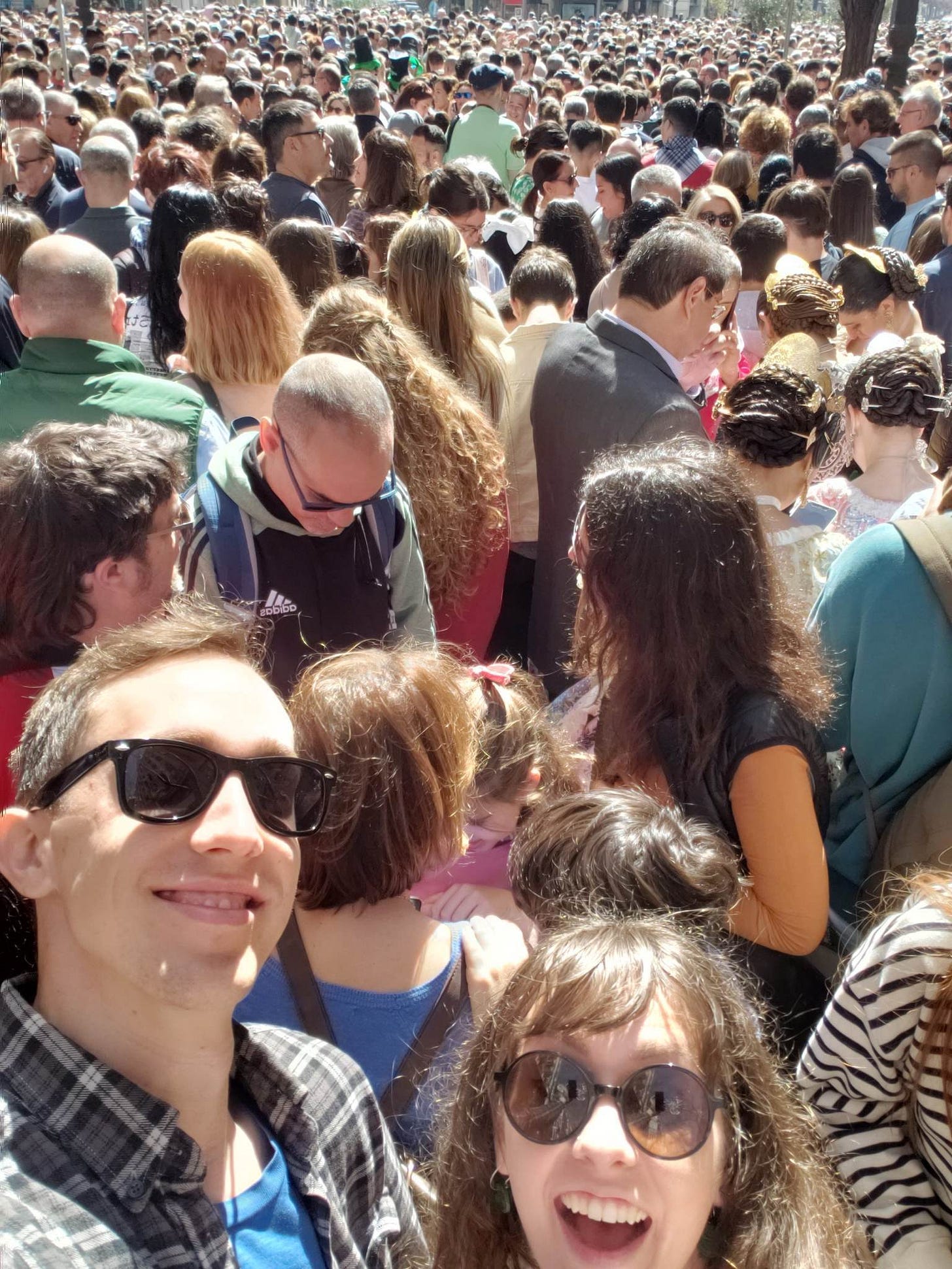 Jeff and Em taking a selfie in an enormous crowd of people