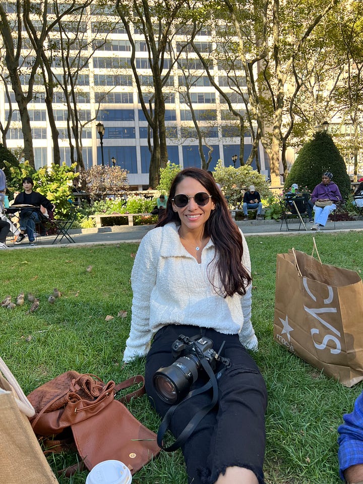 Counter-clockwise from top left: selfie photo of woman with International Center of Photography (ICP) building in background; woman sitting along Bethesda Fountain edge in Central Park; selfie photo of woman at night with central Times Square in the background; woman sitting and leaning back on grass in Bryan Park.