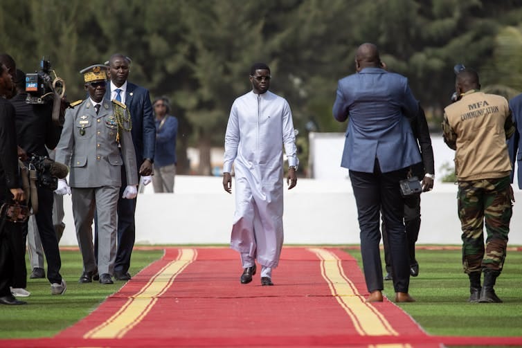 Senegal's president, Bassirou Diomaye Faye, walks down a red carpet. Senegal's president, Bassirou Diomaye Faye, walks down a red carpet.