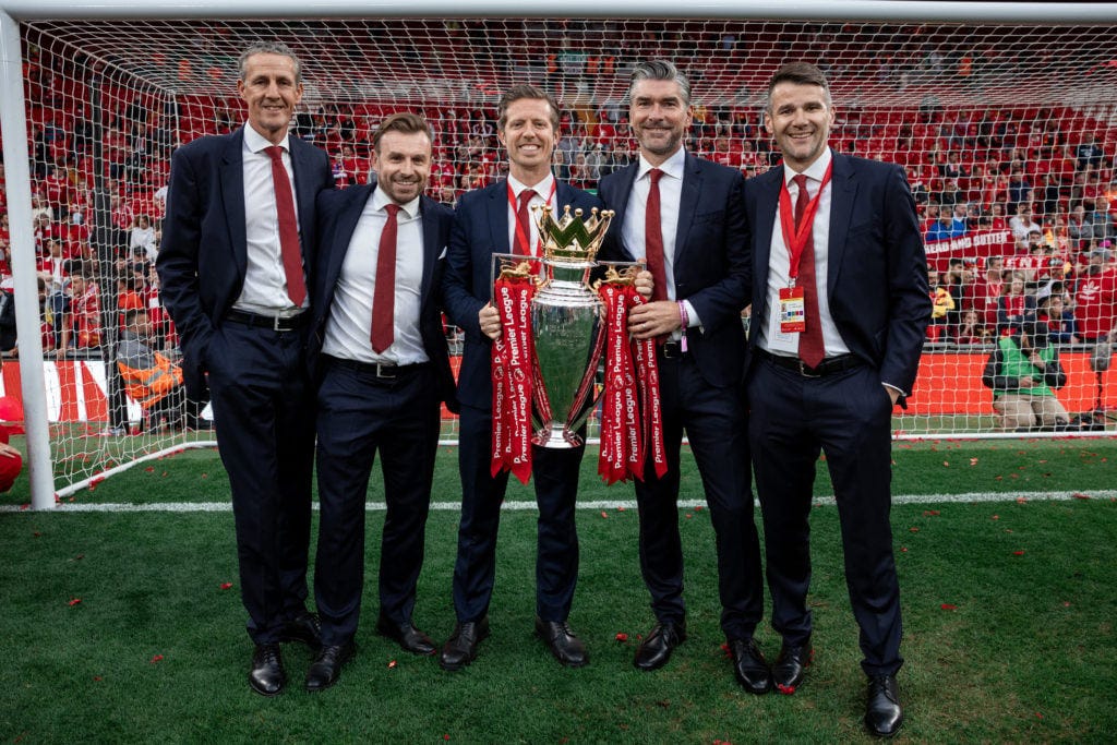 Barry Hunter, Julian Ward, Michael Edwards, Richard Hughes and David Woodfine pose for a photograph with the Premier League trophy, as Liverpool are crowned the Champions of the Premier League for the 2024/25 Season