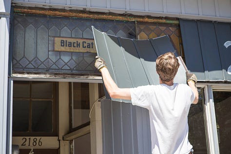 revealing the old hand painted sign at Black Cat Artspace