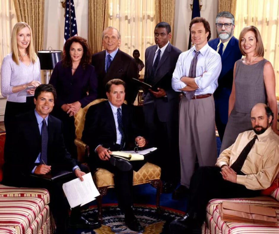 This is a doctored photo of the team from The West Wing in the Oval Office. MK is added to the group shot of government workers (actors) gathered around the seated "President" Jed Bartlett