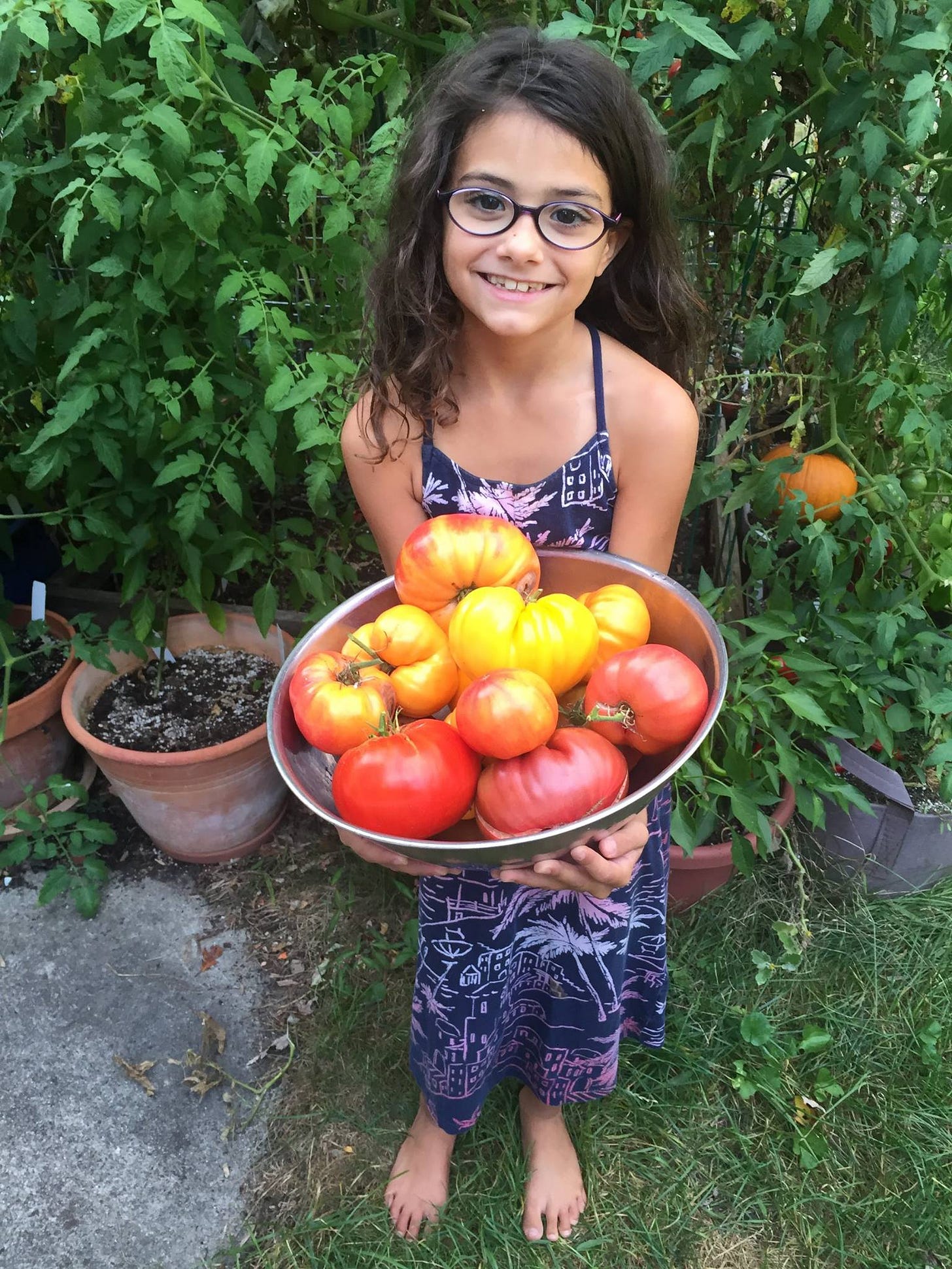 a girl holding just-picked tomatoes