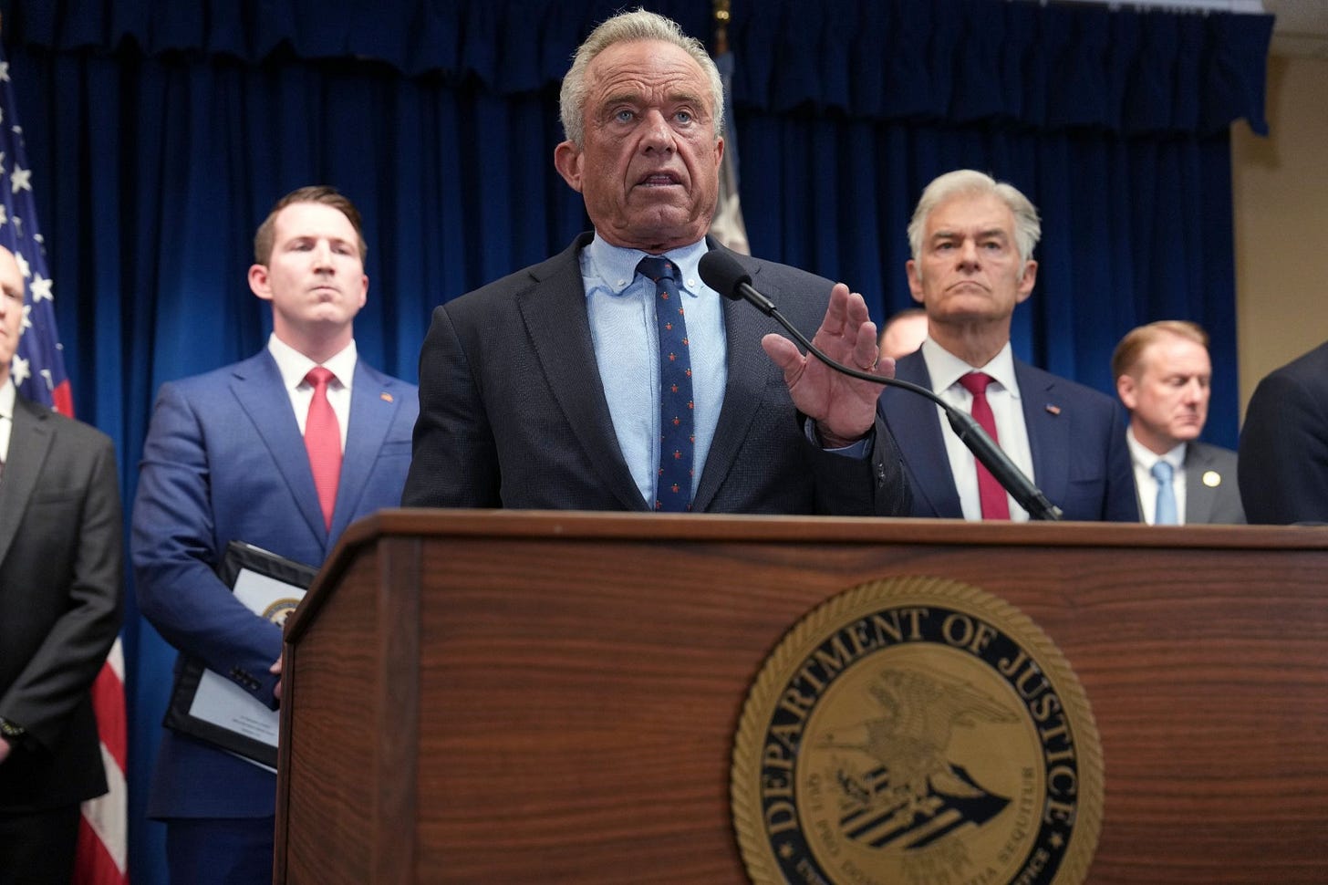 HHS Secretary Robert F. Kennedy Jr. speaks at a Department of Justice podium in Minneapolis, flanked by federal officials. HHS Secretary Robert F. Kennedy Jr. speaks at a Department of Justice podium in Minneapolis, flanked by federal officials.