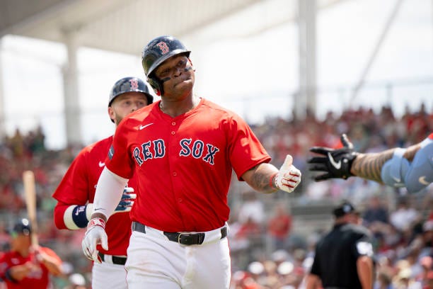 Rafael Devers of the Boston Red Sox reacts after scoring on a a two-run home run hits by Trevor Story of the Boston Red Sox during a Spring Training...