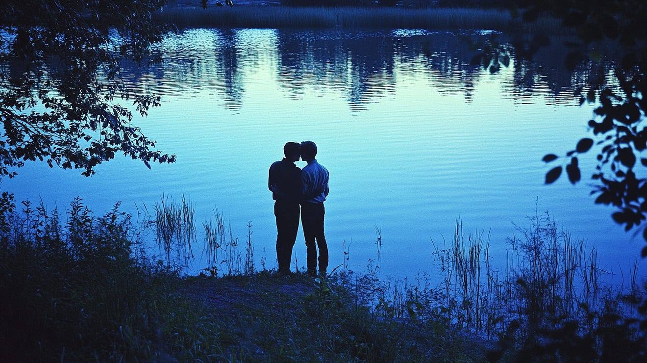 Two people standing close together by a serene lake at dusk, surrounded by foliage, with the water reflecting the twilight sky.