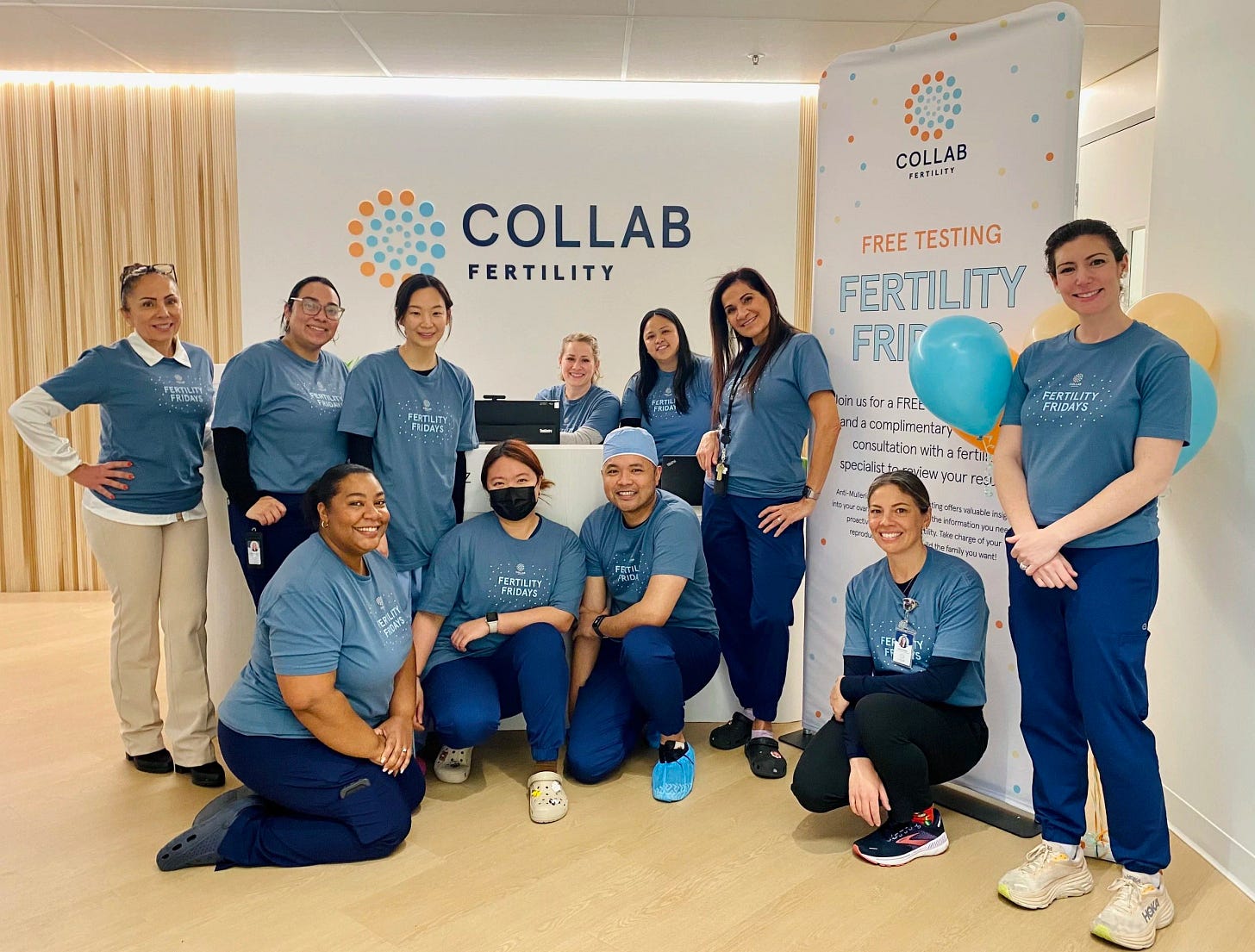 Eleven Collab Fertility team members in matching blue “Fertility Fridays” t-shirts, posing at the clinic reception beside a free testing banner.