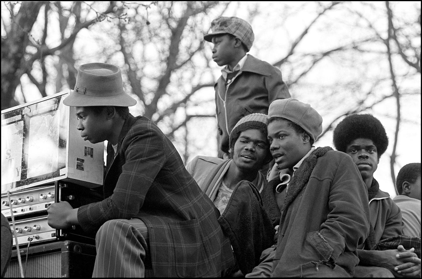 A group of men sitting on a bench

Description automatically generated