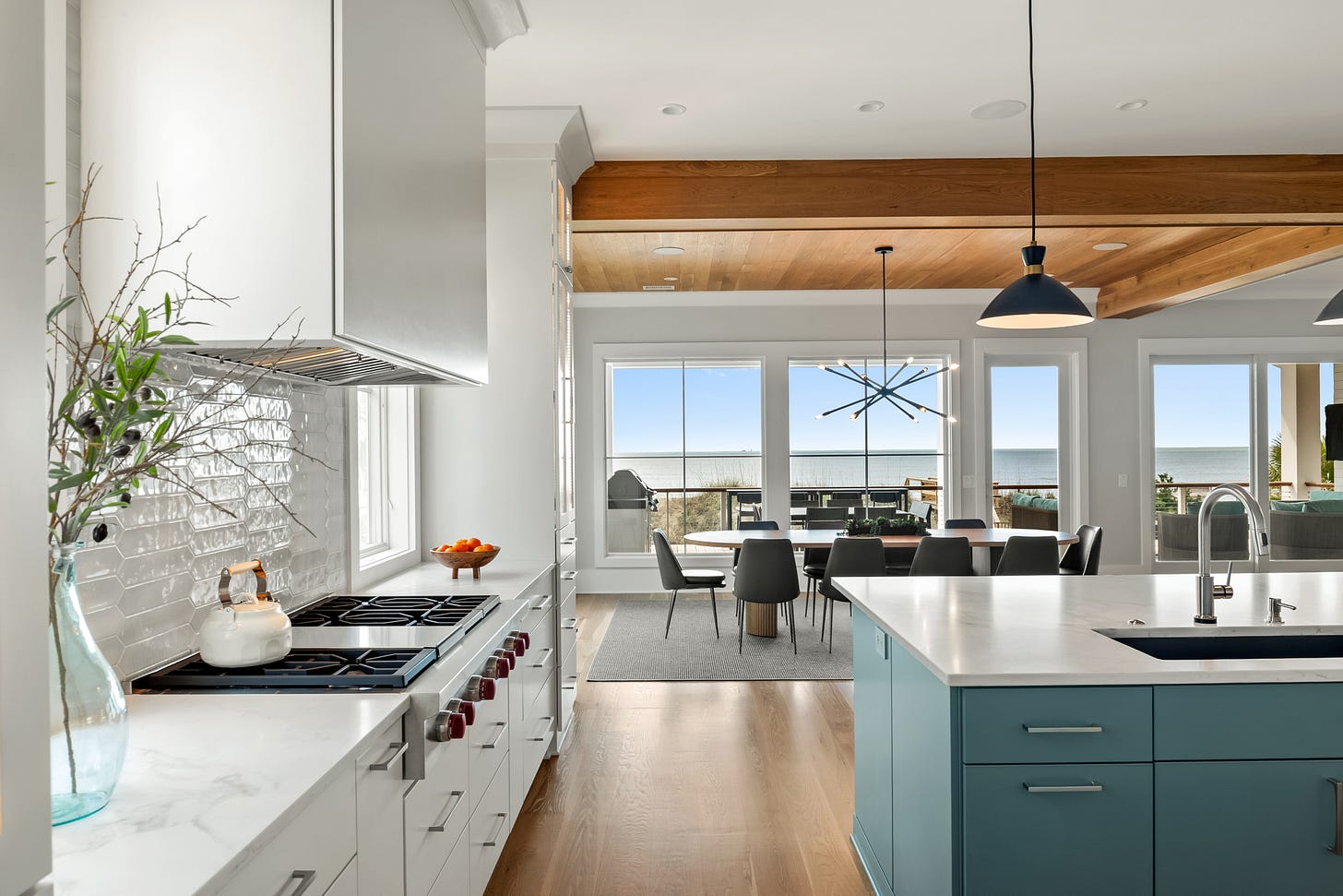 Modern kitchen overlooking a dining room with a gas cooktop and views of the ocean Modern kitchen overlooking a dining room with a gas cooktop and views of the ocean