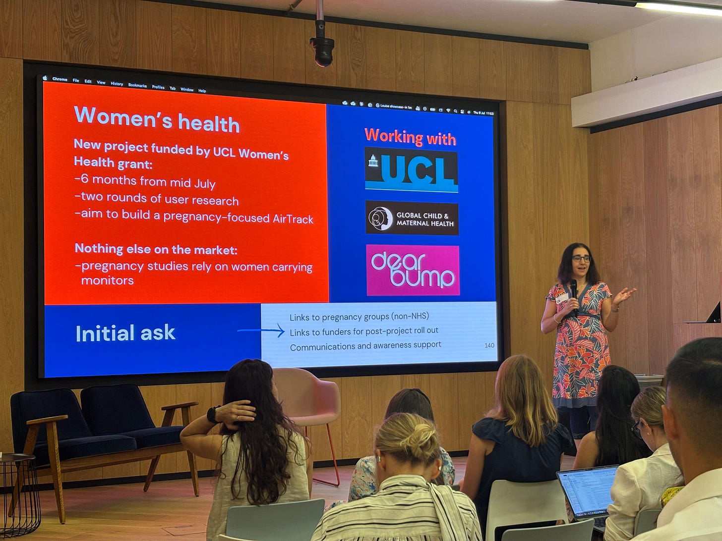 Louise pitching the women's health and air pollution project at an event with a slide on the project and partners