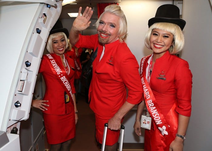 PERTH, AUSTRALIA - MAY 12: Sir Richard Branson waves farewell prior to his flight to Kuala Lumpur at Perth International Airport on May 12, 2013 in Perth, Australia. Sir Richard Branson lost a friendly bet to AirAsia Group Chief Executive Officer Tony Fernandez after wagering on which of their Formula One racing teams would finish ahead of each other in their debut season of the 2010 Formula One Grand Prix in Abu Dhabi and that the loser would serve as a female flight attendant on board the winner's airline. (Photo by Paul Kane/Getty Images)