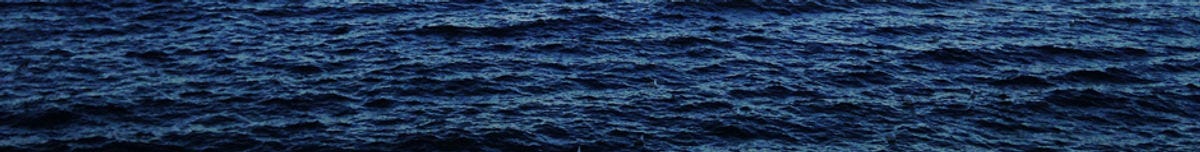 The surface of a dark blue ocean, rippling with small waves