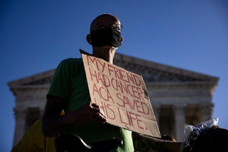Protester holds sign that says 'My friend had cancer. ACA saved his life.' Protester holds sign that says 'My friend had cancer. ACA saved his life.'