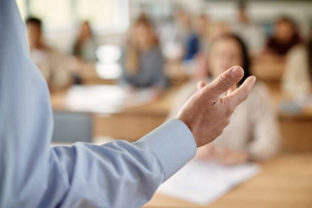 Close-up of teacher giving lecture in the classroom.