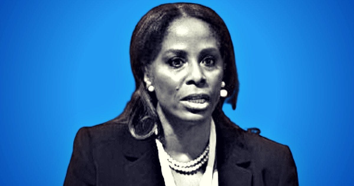 Professional woman speaking at an event with a blue background, showcasing her engagement and authority in discussion.