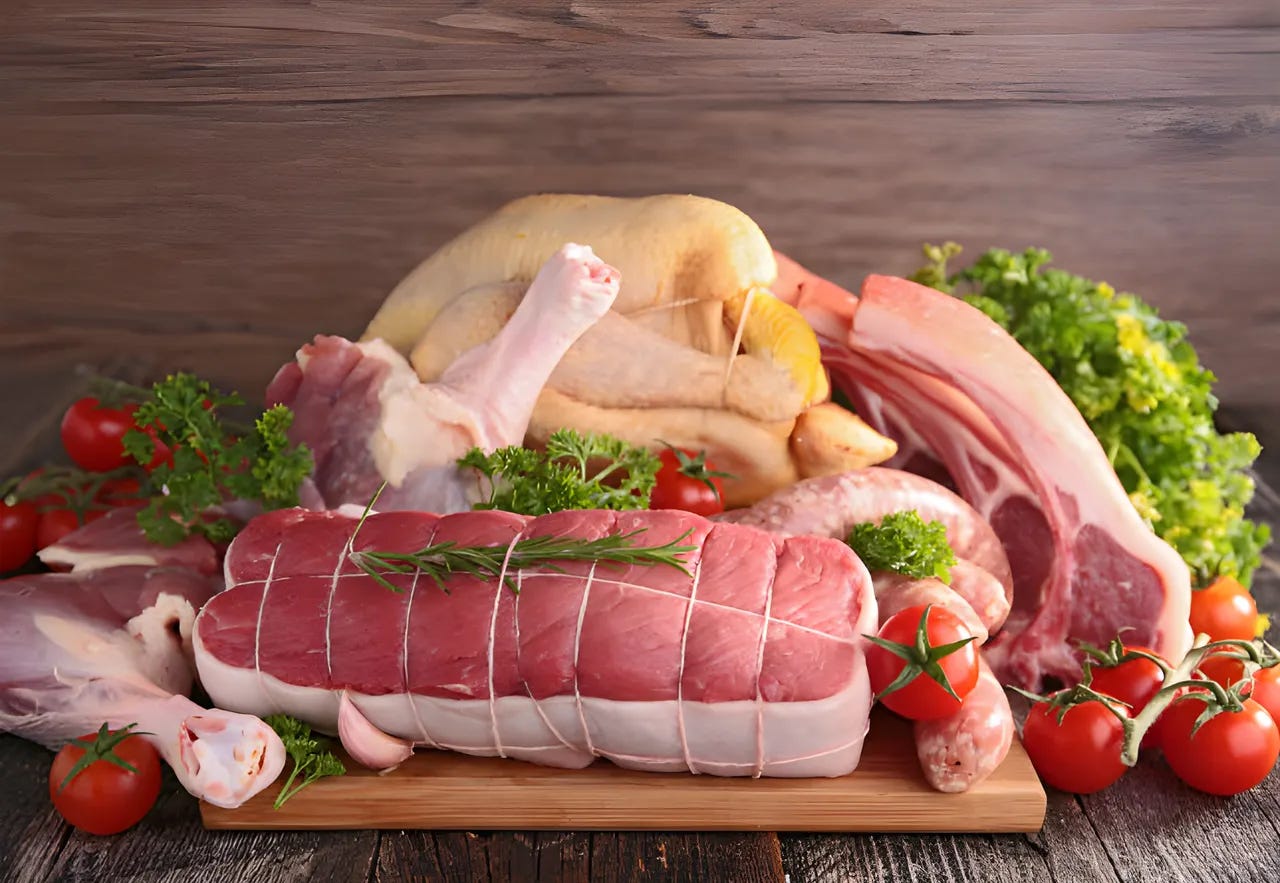 Assortment of raw meat and produce on a cutting board with herbs and tomatoes. Assortment of raw meat and produce on a cutting board with herbs and tomatoes.