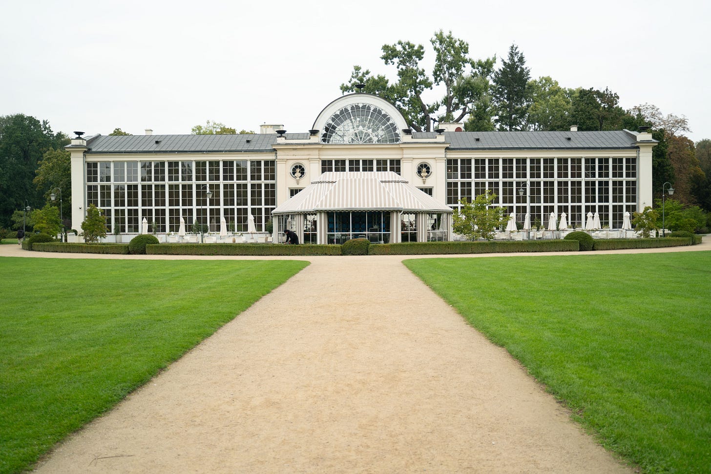 A picture of the Restaurant Belvedere in Łazienki Park, Warsaw. The full building is visible, with a path running through a grass lawn in the foreground.