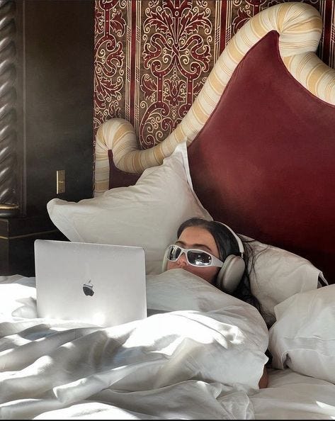 This may contain: a man laying in bed with headphones on using a laptop This may contain: a man laying in bed with headphones on using a laptop