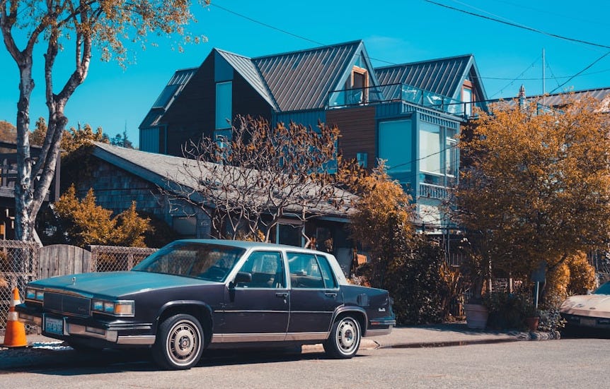 blue sedan parked beside brown tree during daytime blue sedan parked beside brown tree during daytime