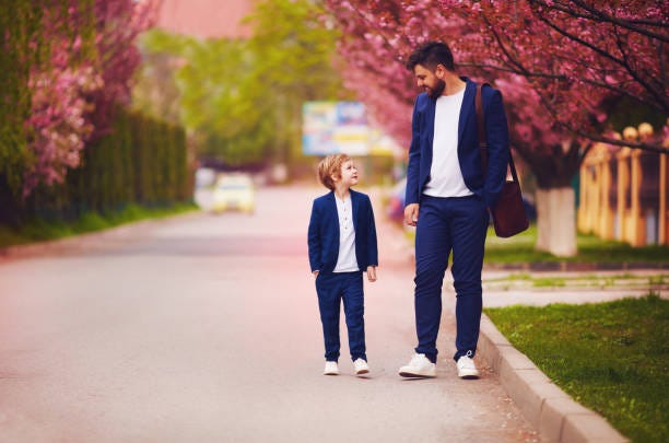 happy father and son walking together along blooming spring street, wearing suits happy father and son walking together along blooming spring street, wearing suits Elegant child stock pictures, royalty-free photos & images
