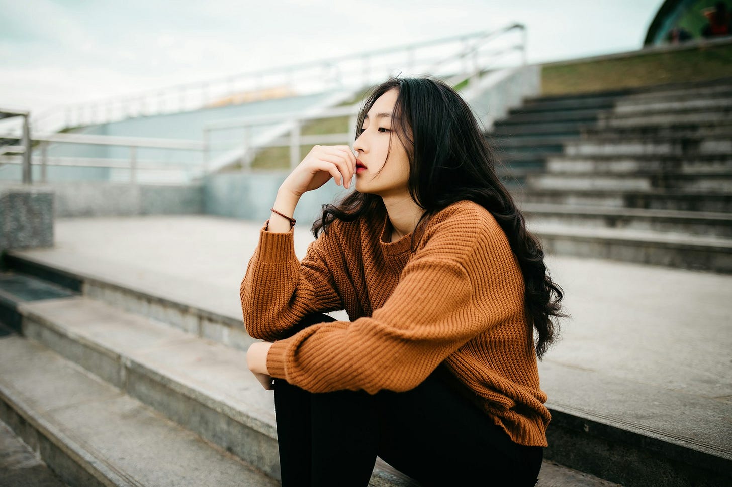 A women thinking on bleachers