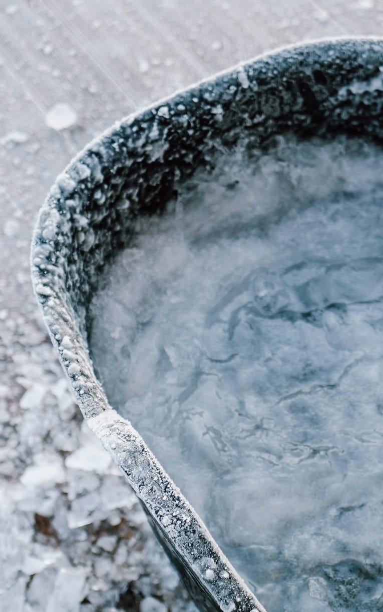 a bucket filled with ice sitting on top of a wooden floor