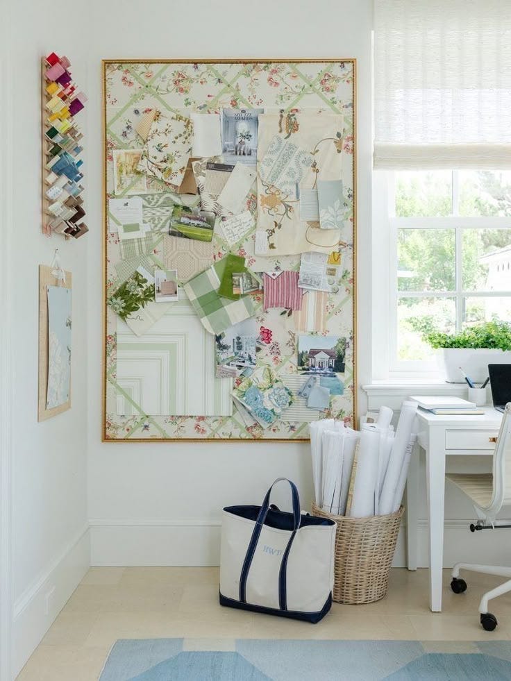 This may contain: a white room with a large painting on the wall next to a chair and desk