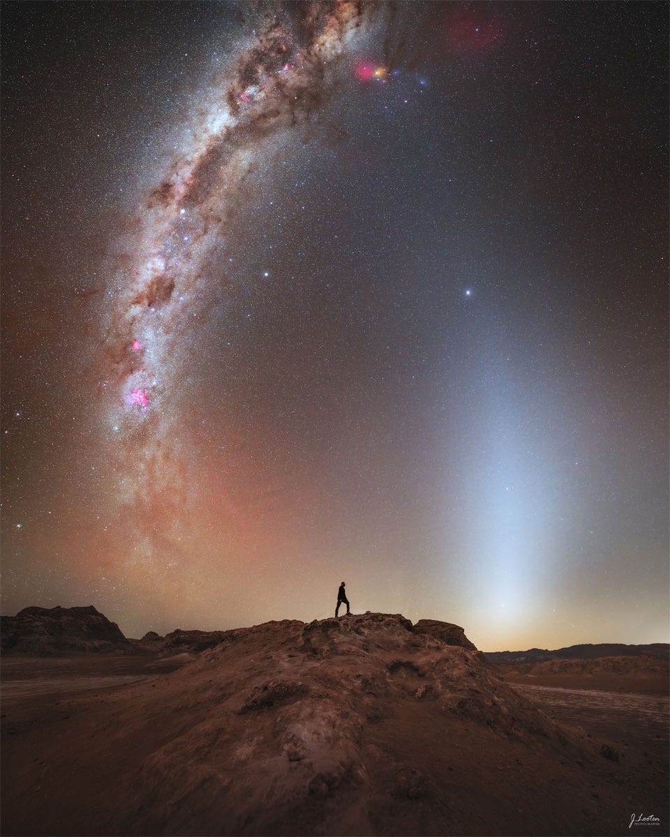 A distant person stands on a rocky landscape. Above is a
starry sky. Rising up from the horizon on either side of
the person are bright arching spires.
Please see the explanation for more detailed information. A distant person stands on a rocky landscape. Above is a
starry sky. Rising up from the horizon on either side of
the person are bright arching spires.
Please see the explanation for more detailed information.