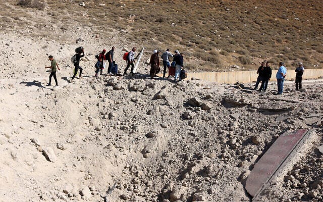 People fleeing intensified fighting in Lebanon walk around a crater caused by an Israeli strike on Hezbollah weapons smuggling infrastructure, in the area of Lebanon's Masnaa border crossing with Syria, on October 4, 2024. (Hassan Jarrah / AFP) People fleeing intensified fighting in Lebanon walk around a crater caused by an Israeli strike on Hezbollah weapons smuggling infrastructure, in the area of Lebanon's Masnaa border crossing with Syria, on October 4, 2024. (Hassan Jarrah / AFP)