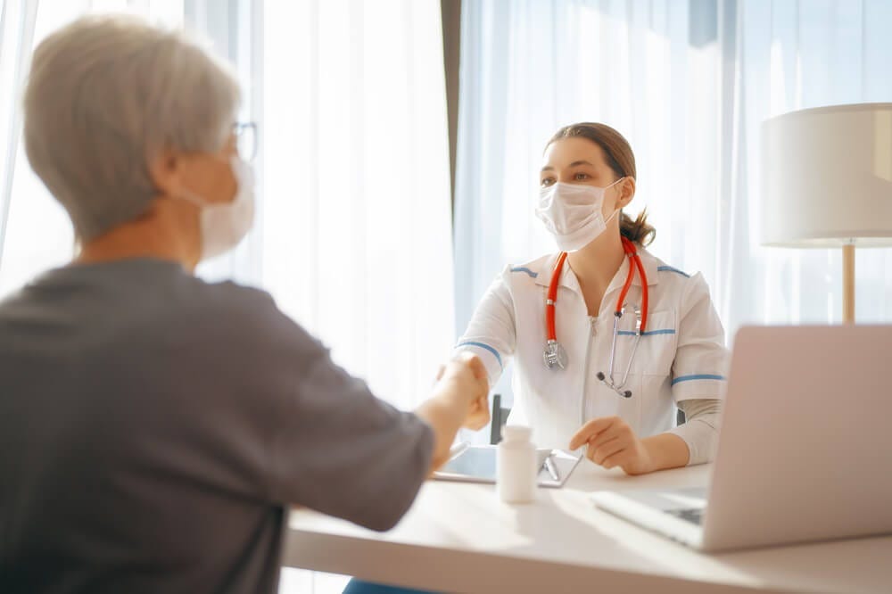 Médica com máscara atende paciente e quer saber qual é a diferença entre clínica e consultório. Médica com máscara atende paciente e quer saber qual é a diferença entre clínica e consultório.