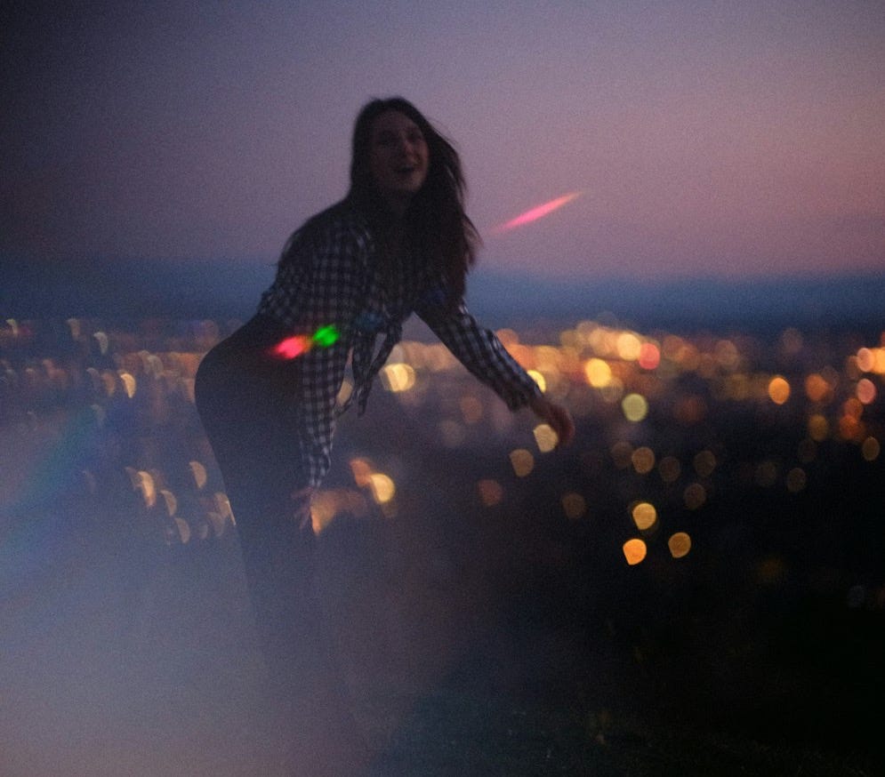 woman in black and white polka dot long sleeve shirt standing on the ground during night woman in black and white polka dot long sleeve shirt standing on the ground during night