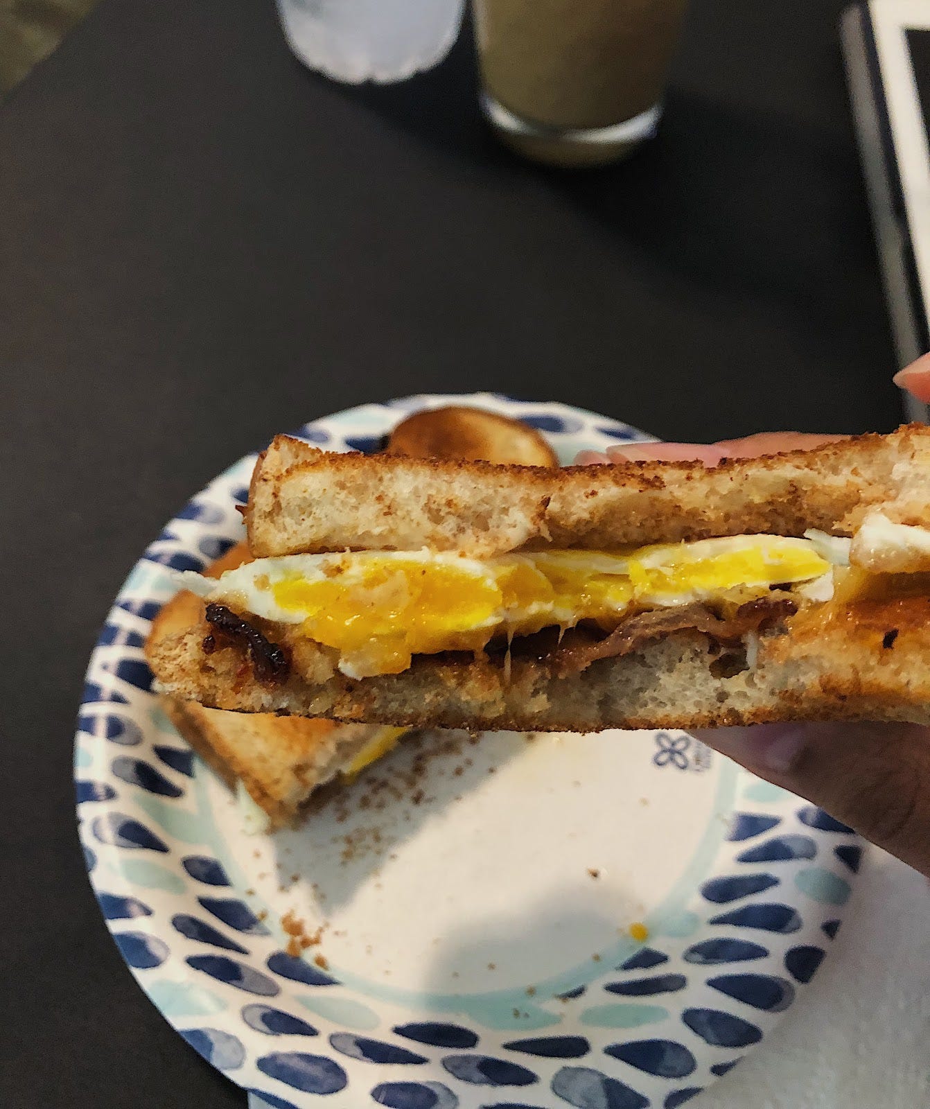 Close up of a bite of egg, cheese, and brown sugar bacon sandwich