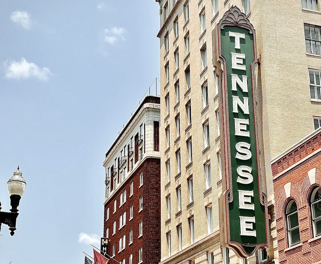 brown concrete building with green and white signage