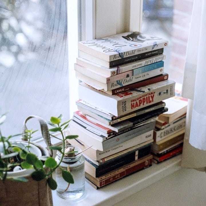 assorted-title book lot beside window assorted-title book lot beside window