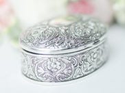 An engraved silver pill box. An engraved silver pill box.