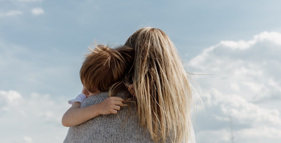 woman in gray shirt covering her face with her hair
