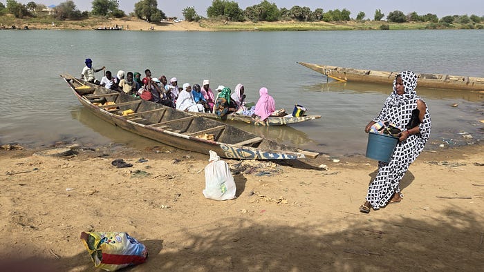 Canoe filled with people on bank of river.