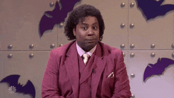 SNL gif. Kenan Thompson dressed in a fancy suit sits in a room with bat cut outs behind him. Something that he heard catches him off guard. He looks away awkwardly while gasping a little, and his eyes go wide with shock. He looks back with an amused look on his face. SNL gif. Kenan Thompson dressed in a fancy suit sits in a room with bat cut outs behind him. Something that he heard catches him off guard. He looks away awkwardly while gasping a little, and his eyes go wide with shock. He looks back with an amused look on his face.