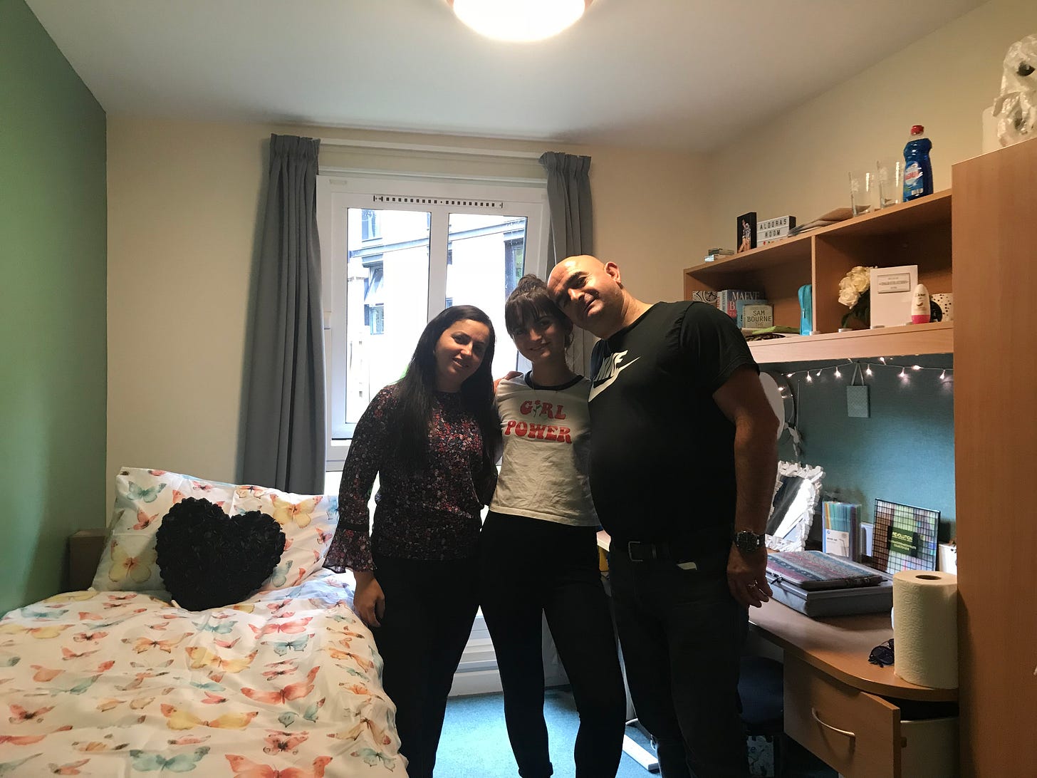 A heartwarming snapshot in my first university bedroom captures a moment of joy, with my mom, dad, and me. Our smiles reflect the excitement and shared pride of embarking on a new chapter together.