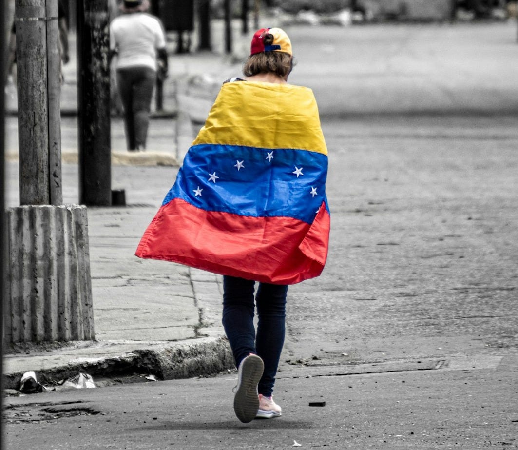 A person walking down a street holding a flag