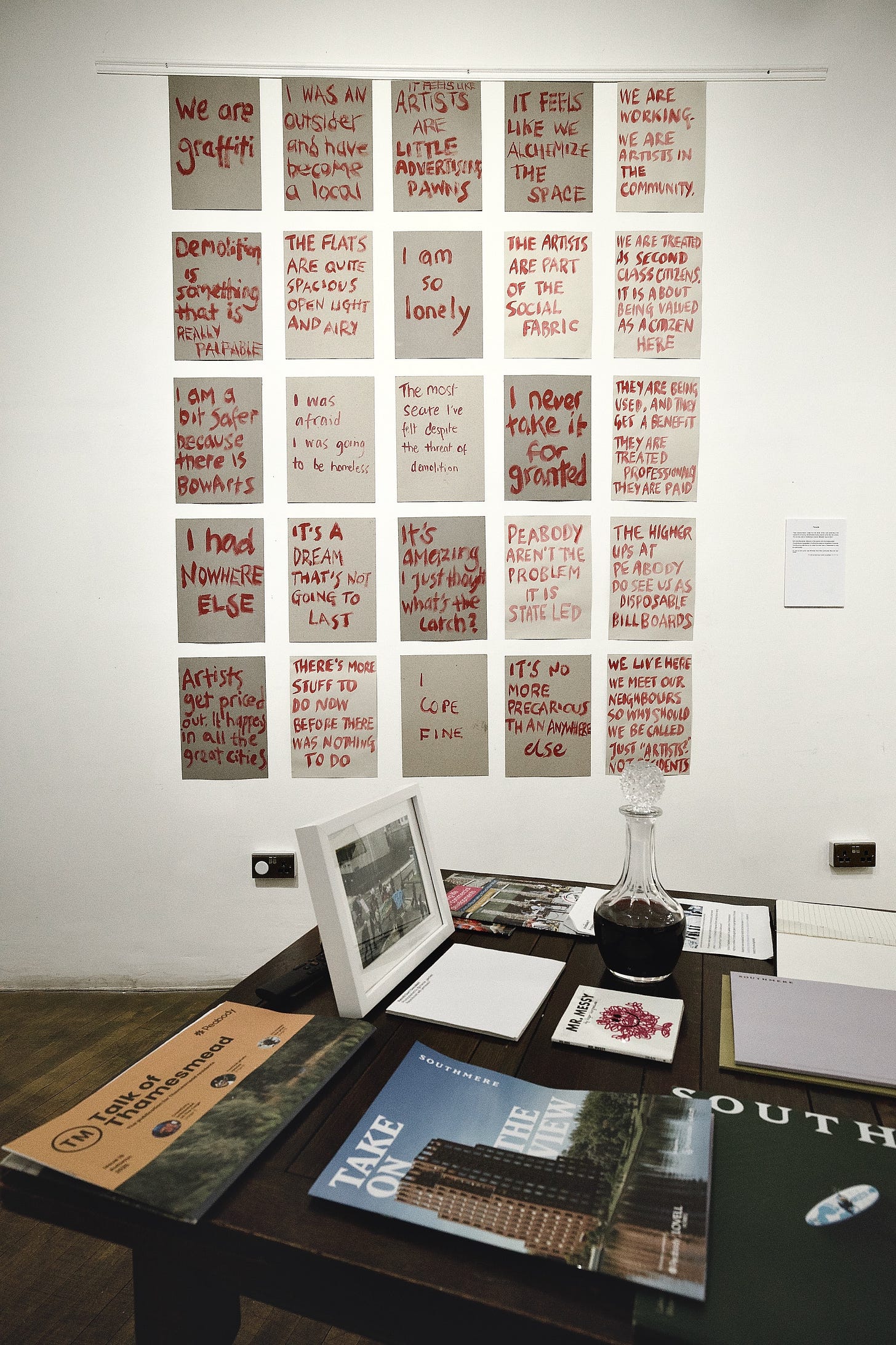 Large colorful crocheted map hanging on a white wall, featuring text and stitched geographic lines. Large colorful crocheted map hanging on a white wall, featuring text and stitched geographic lines.