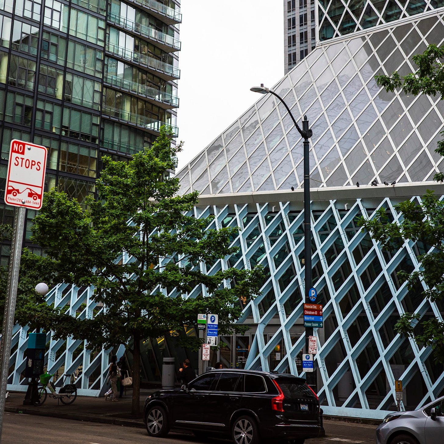 The exterior of the Seattle Public Library Central branch, which has walls angled like a pyramid and composed of latticed metal i-beams surrounding glass.