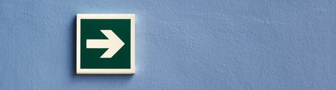 white and green arrow sign